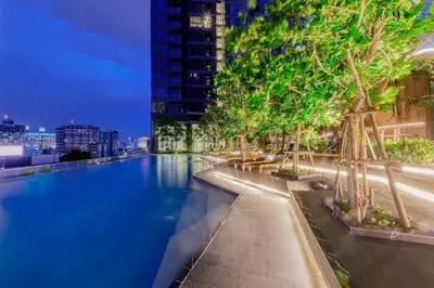 a swimming pool with trees on the side of a building at High Floor Apt with Large Living Room Pool and Gym in Ban Na Song
