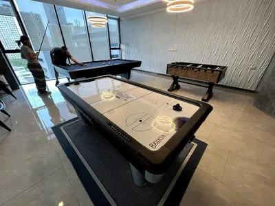a ping pong table in a room with two people playing pool at 40th Fl Skyview with Standing Desk Pool and Gym in Ban Na Song