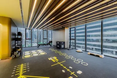 a gym in a building with large windows at 40th Fl Skyview with Standing Desk Pool and Gym in Ban Na Song