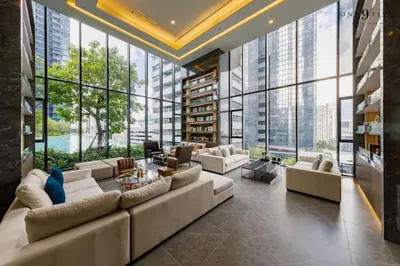 a living room with a large couch and large windows at 40th Fl Skyview with Standing Desk Pool and Gym in Ban Na Song