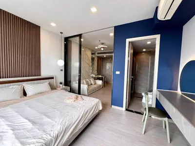 a bedroom with a white bed and a blue wall at 53Fl Skyview with King Bed Pool and Gym MRT200m in Ban Na Song
