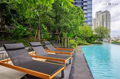 a row of chaise lounge chairs next to a swimming pool at 53Fl Skyview with King Bed Pool and Gym MRT200m in Ban Na Song
