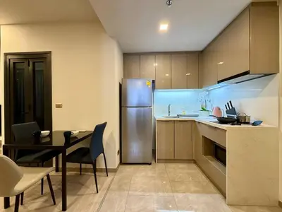 a kitchen with a table and a stainless steel refrigerator at Peak Luxury Living with King Bed Golf Pool and Gym in Ban Na Song