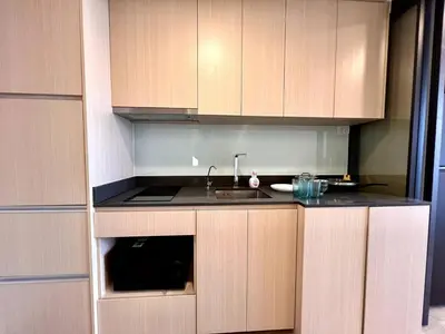 a kitchen with wooden cabinets and a sink at High Floor Loft with Pool and Gym in Ban Na Song