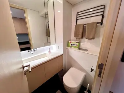 a white bathroom with a toilet and a sink at High Floor Loft with Pool and Gym in Ban Na Song