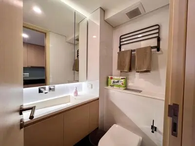 a white bathroom with a sink and a mirror at High Floor Loft with Pool and Gym in Ban Na Song
