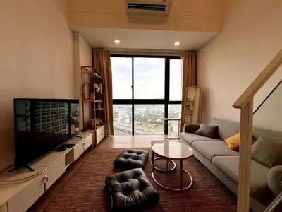 a living room with a couch and a flat screen tv at High Floor Loft with Pool and Gym in Ban Na Song