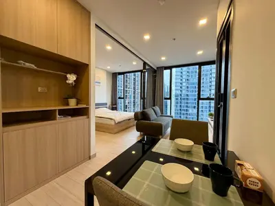 a living room with a couch and a table in a room at Spacious Apt with King Bed Pool and Gym MRT200m in Bangkok