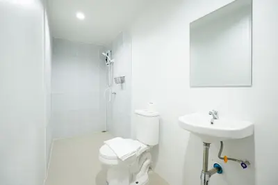 a white bathroom with a toilet and a sink at XX Snap inn Sukhumvit 1 สแนป สุขุมวิท ซอย 1 in Makkasan