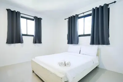 two wedding rings on a bed in a room with windows at XX Snap inn Sukhumvit 1 สแนป สุขุมวิท ซอย 1 in Makkasan