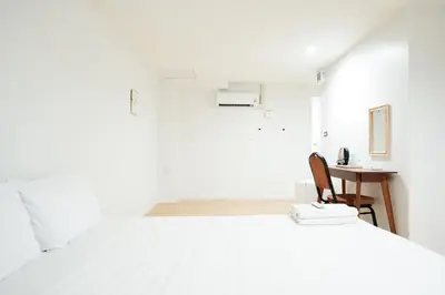a white room with a desk and a bed at XX สแนปอิน สุขุมวิท 1 - Snap Inn Sukhumvit 1 in Makkasan