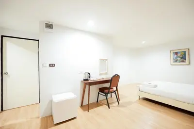 a bedroom with a bed and a desk with a chair at XX สแนปอิน สุขุมวิท 1 - Snap Inn Sukhumvit 1 in Makkasan