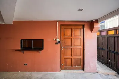 an orange wall with a door and a window at XX สแนปอิน สุขุมวิท 1 - Snap Inn Sukhumvit 1 in Makkasan