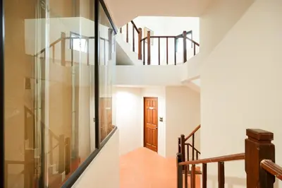 a staircase in a house with a glass wall at xx Snap Inn Sukhumvit 1 - สแนป อินน์ สุขุมวิท 1 in Makkasan