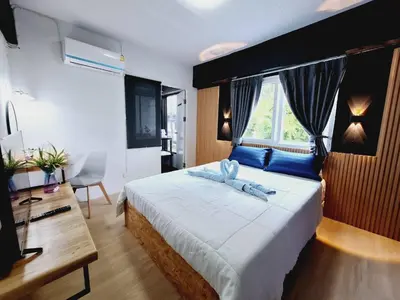 a bedroom with a large bed and a window at Irich Theparak S207- Bts-Chang Erawan 2kms in Ban Khlong Hua Sakae