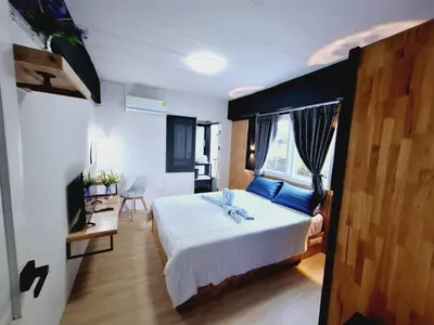 a bedroom with a large bed with blue pillows at Irich Theparak S207- Bts-Chang Erawan 2kms in Ban Khlong Hua Sakae