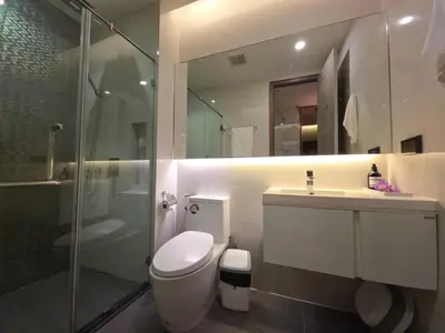a bathroom with a toilet and a shower and a sink at Mayfair Bangkok in Bangkok