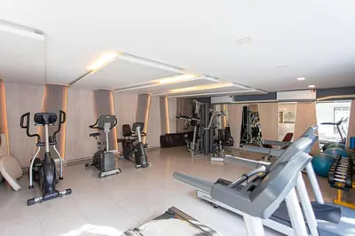 a gym with several treadmills and exercise bikes at Dazzle Residence ByPinny in Bangkok