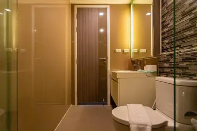 a bathroom with a shower and a toilet and a sink at Dazzle Residence ByPinny in Bangkok