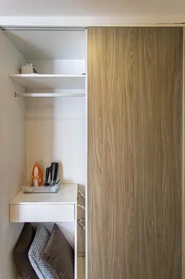 a room with a closet with a wooden door at Dazzle Residence ByPinny in Bangkok