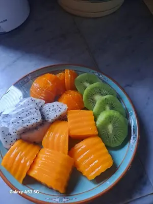 a plate of fruit with oranges and kiwis and kiwi at The room, luxury condo 21fl 1 Bedroom ,near bts in Bangkok