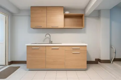 a kitchen with wooden cabinets and a sink at Niche Space Sripraya- Samyan in Bangkok