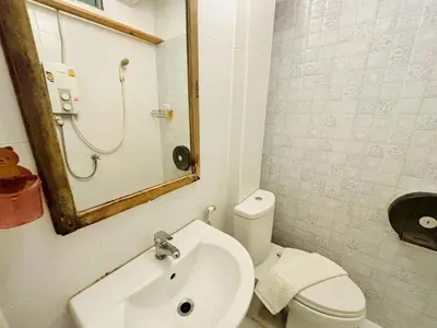 a bathroom with a toilet and a sink and a mirror at Sukhum Charoen Krung Tak-Sin bridge guest house in Bangkok