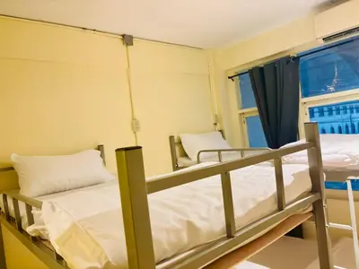two bunk beds in a room with a window at Sukhum Charoen Krung Tak-Sin bridge guest house in Bangkok