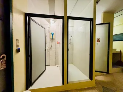 a bathroom with two glass doors and a shower at Sukhum Charoen Krung Tak-Sin bridge guest house in Bangkok
