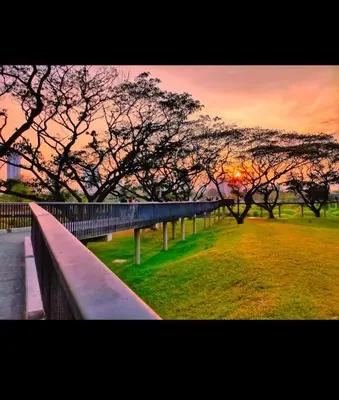 a park with a fence and trees at sunset at Beautiful 1 bedroom Appartment in the Heart of Bangkok in Bangkok