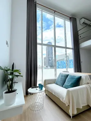 a bedroom with a bed and a large window at Komfort Duplex BTS Ratchayothin in Bangkok