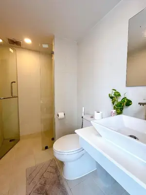 a bathroom with a toilet and a sink and a shower at Komfort Duplex BTS Ratchayothin in Bangkok