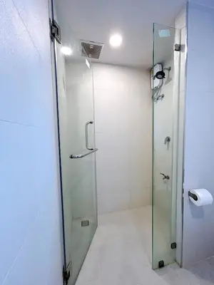 a shower with a glass door in a bathroom at Komfort Duplex BTS Ratchayothin in Bangkok