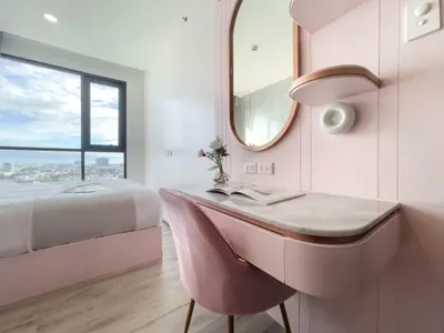 a bathroom with a pink desk and a bed at Near BTS Bearing l Rooftop pool and gym in Bangkok