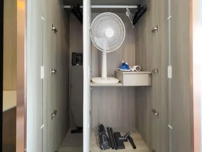 a bathroom with a fan sitting on a shelf at Near BTS Bearing l Rooftop pool and gym in Bangkok