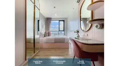 a bedroom with a bed and a desk and a mirror at Near BTS Bearing l Rooftop pool and gym in Bangkok