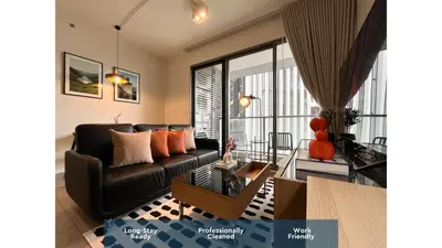 a living room with a couch and a table at 500m to BTS l Large 50 sqm l Workspace l By Sontana in Bangkok