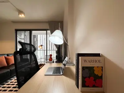 a living room with a laptop on a table at 500m to BTS l Large 50 sqm l Workspace l By Sontana in Bangkok