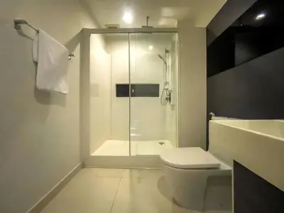 a bathroom with a shower and a toilet and a sink at Near BTS l Central Sukhumvit l Pool and Garden l Sontana in Bangkok