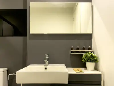 a bathroom with a white sink and a mirror at Near BTS l Central Sukhumvit l Pool and Garden l Sontana in Bangkok