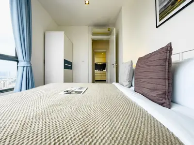 a bedroom with a large bed and a window at Near BTS l Central Sukhumvit l Pool and Garden l Sontana in Bangkok