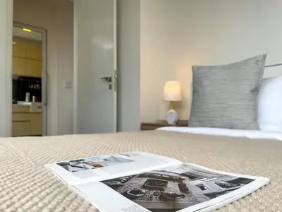 a magazine sitting on top of a bed at Near BTS l Central Sukhumvit l Pool and Garden l Sontana in Bangkok