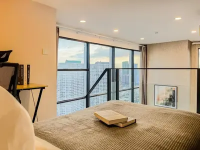 a bedroom with a bed with a book on it at Duplex near BTS l Rooftop Pool l Skyline l Sontana in Bangkok