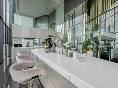 a white counter with two stools in a large room at Duplex near BTS l Rooftop Pool l Skyline l Sontana in Bangkok