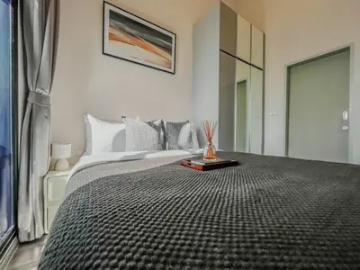 a bedroom with a large bed and a window at Duplex near BTS l Rooftop Pool l Skyline l Sontana in Bangkok