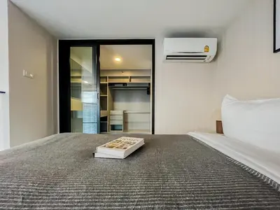 a bedroom with a bed with a book on it at Duplex near BTS l Rooftop Pool l Skyline l Sontana in Bangkok