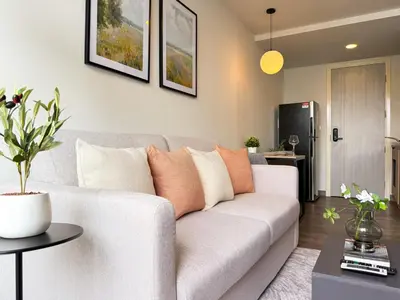a living room with a couch and a table at Near BTS - Near Iconsiam - Pool and Gym - Sontana in Bangkok