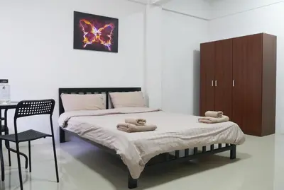 a bedroom with a bed with two towels on it at Baan Mai Guest House in Bangkok
