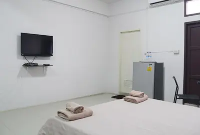 a room with a bed with two towels on it at Baan Mai Guest House in Bangkok