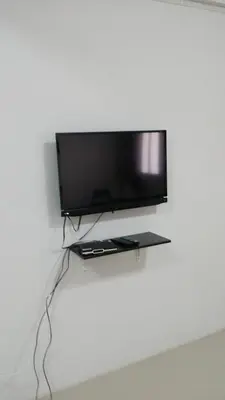 a flat screen tv hanging on a wall at Baan Mai Guest House in Bangkok